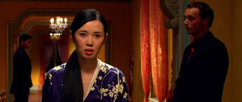 A woman in a kimono standing in front of a mirror