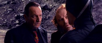 Movie still from “Speed Racer” (2008), directed by Lilly Wachowski – A group of men standing next to each other; Close Up shot, Over the shoulder angle