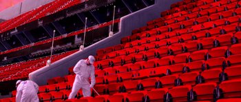Movie still from “Speed Racer” (2008), directed by Lilly Wachowski – A man in a white suit is cleaning the seats of an arena; Extreme Wide shot, High angle