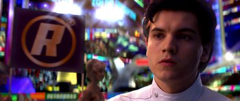 Movie still from “Speed Racer” (2008), directed by Lilly Wachowski – A man in a white dress shirt is in a city; Close Up shot, Over the shoulder angle