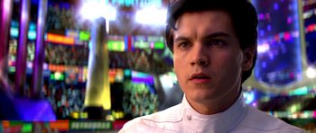 Movie still from “Speed Racer” (2008), directed by Lilly Wachowski – A man in a white shirt and a hat is looking at the camera; Close Up shot, Over the shoulder angle