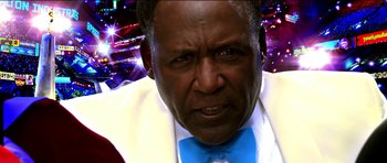 Movie still from “Speed Racer” (2008), directed by Lilly Wachowski – An older man wearing a blue bow tie; Extreme Close Up shot, Low angle