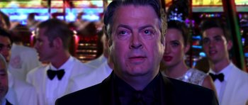 Movie still from “Speed Racer” (2008), directed by Lilly Wachowski – A person wearing a suit and tie; Close Up shot, Over the shoulder angle