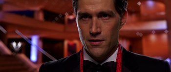 Movie still from “Speed Racer” (2008), directed by Lilly Wachowski – A person wearing a suit and tie; Close Up shot, Over the shoulder angle