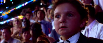 Movie still from “Speed Racer” (2008), directed by Lilly Wachowski – A young boy in a white shirt and black bow tie; Close Up shot, Low angle
