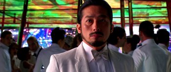 Movie still from “Speed Racer” (2008), directed by Lilly Wachowski – A person wearing a suit and a bow tie; Close Up shot, Low angle