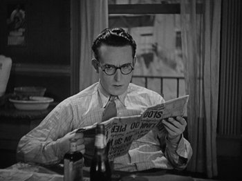 Movie still from “Speedy” (1928), directed by Ted Wilde – A man sitting at a table reading a newspaper; Close Up shot, High angle