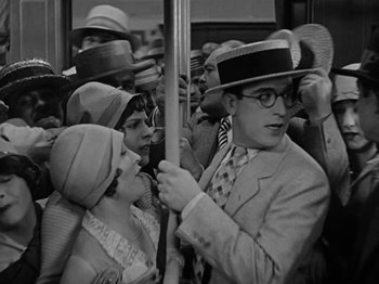 Movie still from “Speedy” (1928), directed by Ted Wilde – A group of people riding on a subway train; Medium shot, High angle