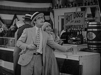 Movie still from “Speedy” (1928), directed by Ted Wilde – A man and a woman standing next to each other; Medium shot, High angle