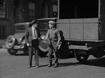 Movie still from “Speedy” (1928), directed by Ted Wilde – Two men standing on the side of the road shaking hands; Wide shot, Low angle