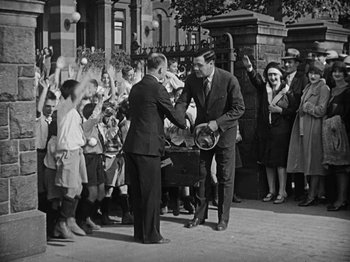 Movie still from “Speedy” (1928), directed by Ted Wilde – Two men shaking hands in front of a group of onlookers; Wide shot, High angle