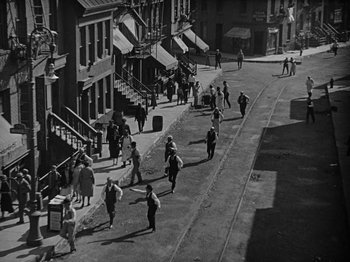 Movie still from “Speedy” (1928), directed by Ted Wilde – A black and white photo of people walking down a street; Extreme Wide shot, High angle