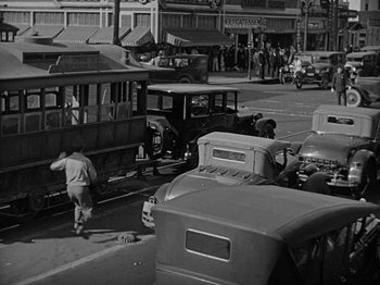 Movie still from “Speedy” (1928), directed by Ted Wilde – An old photo of an intersection with a bus and cars; Extreme Wide shot, High angle