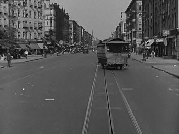 Movie still from “Speedy” (1928), directed by Ted Wilde – An old photo of a trolley on a street; Extreme Wide shot, High angle