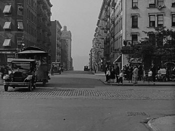 Movie still from “Speedy” (1928), directed by Ted Wilde – An old photo of a city street with people walking on the sidewalk; Extreme Wide shot, High angle