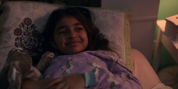 Movie still from “Spin” (2021), directed by Manjari Makijany – A little girl laying in a bed with a unicorn blanket; Close Up shot, Over the shoulder angle