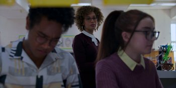 Movie still from “Spin” (2021), directed by Manjari Makijany – A woman standing in front of a group of other people; Medium shot, Over the shoulder angle
