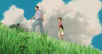 Movie still from “Spirited Away” (2001), directed by Hayao Miyazaki – A man and two children walking on a grassy hill; Extreme Wide shot, Low angle
