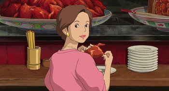 Movie still from “Spirited Away” (2001), directed by Hayao Miyazaki – An animated picture of a woman holding a piece of food; Medium shot, High angle
