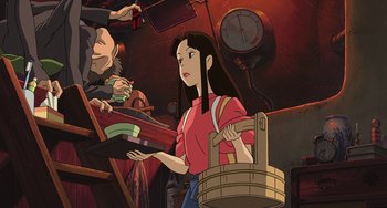 Movie still from “Spirited Away” (2001), directed by Hayao Miyazaki – An animated woman holding a basket in her hand; Medium shot, Low angle