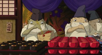Movie still from “Spirited Away” (2001), directed by Hayao Miyazaki – Two people in white shirts and hats are at a table; Medium shot, High angle