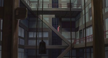 Movie still from “Spirited Away” (2001), directed by Hayao Miyazaki – A person standing in a building looking out a window; Extreme Wide shot, Overhead angle