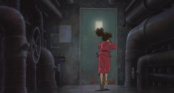 Movie still from “Spirited Away” (2001), directed by Hayao Miyazaki – An animated scene of a person walking in front of an open door; Wide shot, High angle