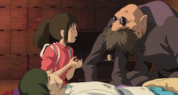 Movie still from “Spirited Away” (2001), directed by Hayao Miyazaki – An animated scene of a woman and a man talking to each other; Medium shot, Over the shoulder angle