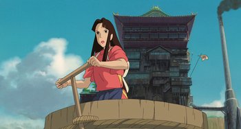 Movie still from “Spirited Away” (2001), directed by Hayao Miyazaki – An animated picture of an asian woman in a red shirt; Wide shot, Low angle