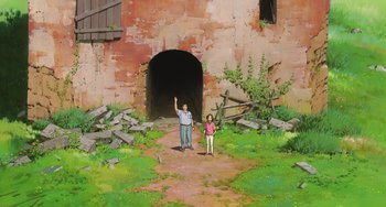 Movie still from “Spirited Away” (2001), directed by Hayao Miyazaki – A man and a girl standing in front of an abandoned building; Extreme Wide shot, Low angle