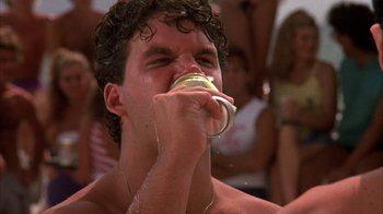 Movie still from “Spring Break” (1983), directed by Sean S. Cunningham – A young man is drinking from a water bottle; Close Up shot, Low angle