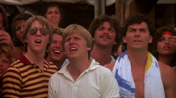 Movie still from “Spring Break” (1983), directed by Sean S. Cunningham – A group of men standing next to each other laughing; Close Up shot, Low angle