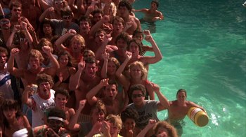 Movie still from “Spring Break” (1983), directed by Sean S. Cunningham – A large group of young people in a pool; Wide shot, High angle