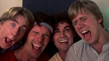 Movie still from “Spring Break” (1983), directed by Sean S. Cunningham – A group of men laughing together with their mouths wide open; Close Up shot, Overhead angle