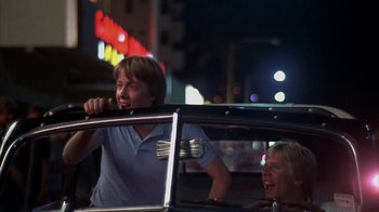 Movie still from “Spring Break” (1983), directed by Sean S. Cunningham – A man and a woman in the back seat of a car; Medium shot, Low angle
