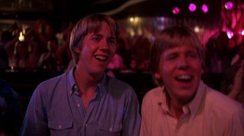 Movie still from “Spring Break” (1983), directed by Sean S. Cunningham – Two young men are laughing together at a party; Close Up shot, Low angle