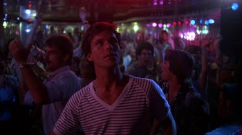 Movie still from “Spring Break” (1983), directed by Sean S. Cunningham – A crowd of people in a room with lights; Medium shot, Low angle