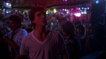 Movie still from “Spring Break” (1983), directed by Sean S. Cunningham – A man standing in front of a crowd of people; Medium shot, Low angle