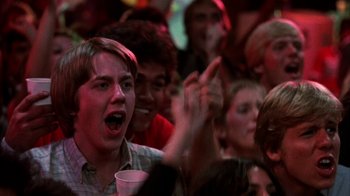 Movie still from “Spring Break” (1983), directed by Sean S. Cunningham – A group of young people sitting in front of an audience; Close Up shot, Low angle