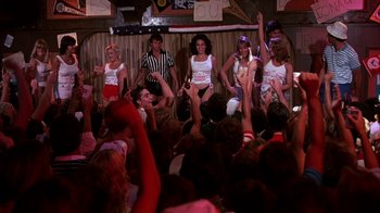 Movie still from “Spring Break” (1983), directed by Sean S. Cunningham – A group of young people are dancing in front of an audience; Wide shot, High angle