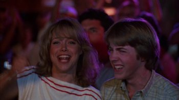 Movie still from “Spring Break” (1983), directed by Sean S. Cunningham – A woman and a man are smiling for the camera; Close Up shot, Low angle