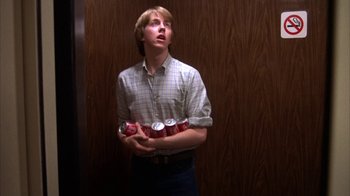 Movie still from “Spring Break” (1983), directed by Sean S. Cunningham – A man holding a can of soda in his hands; Medium shot, Low angle