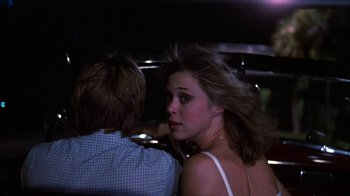 Movie still from “Spring Break” (1983), directed by Sean S. Cunningham – A man and a woman are standing together in the dark; Close Up shot, Over the shoulder angle