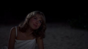 Movie still from “Spring Break” (1983), directed by Sean S. Cunningham – A woman in a white dress sitting in the dark; Close Up shot, Over the shoulder angle