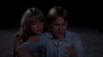 Movie still from “Spring Break” (1983), directed by Sean S. Cunningham – A man and a woman sitting next to each other in a dark room; Close Up shot, Over the shoulder angle