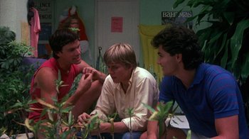 Movie still from “Spring Break” (1983), directed by Sean S. Cunningham – A group of young men sitting next to each other in a room; Medium shot, Low angle