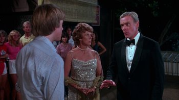 Movie still from “Spring Break” (1983), directed by Sean S. Cunningham – A group of people standing next to each other in a room; Medium shot, Over the shoulder angle