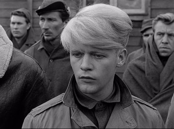 Movie still from “Stalag 17” (1953), directed by Billy Wilder – Black and white photograph of a young man in a military uniform; Close Up shot, Over the shoulder angle