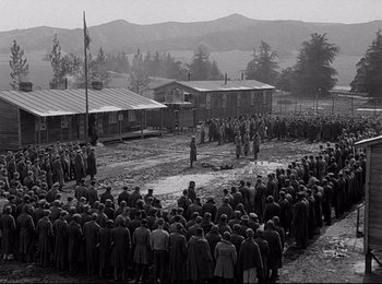Movie still from “Stalag 17” (1953), directed by Billy Wilder – A large group of people standing in a field; Extreme Wide shot, High angle