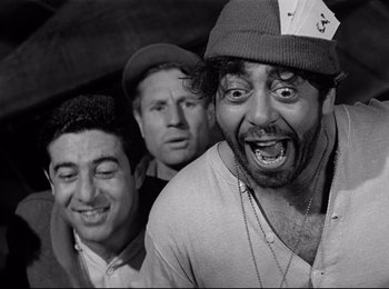 Movie still from “Stalag 17” (1953), directed by Billy Wilder – A group of men standing next to each other; Medium shot, High angle